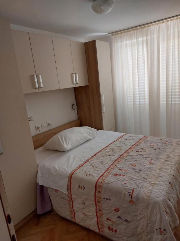 a bedroom with a large bed and a window at Apartments Mlacovic in Rab