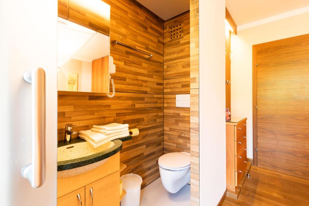 a bathroom with wooden walls and a toilet at Haus Bergblick in Fuschl am See