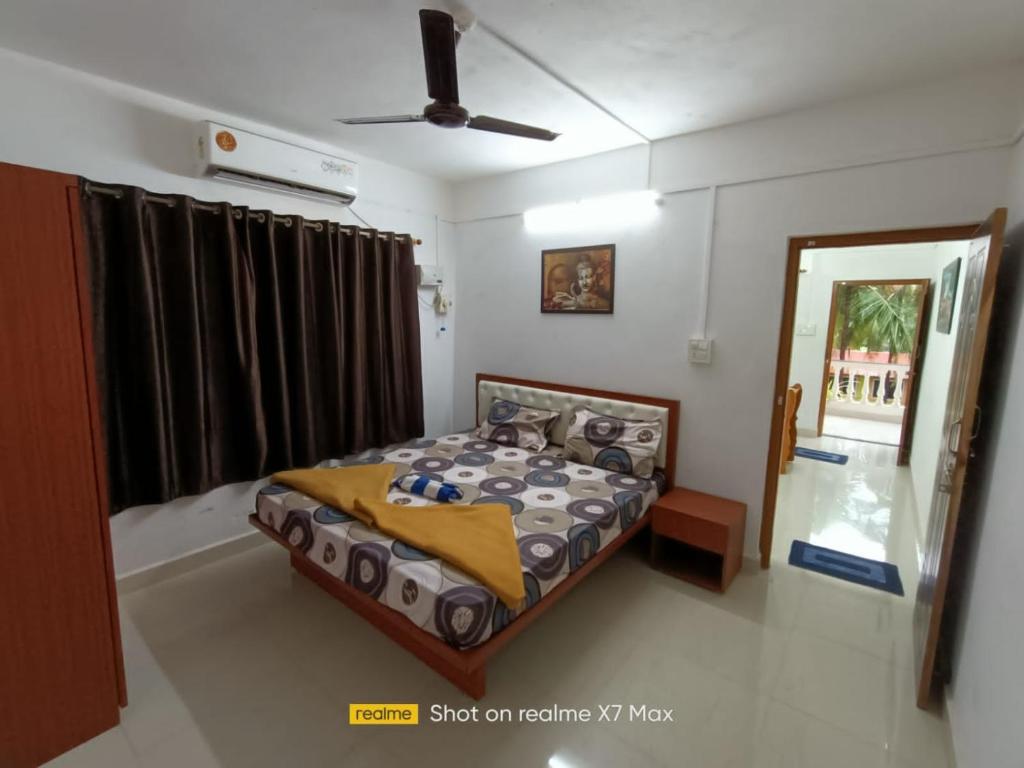 a bedroom with a bed and a window at Palolem Sunrise Apartment in Palolem