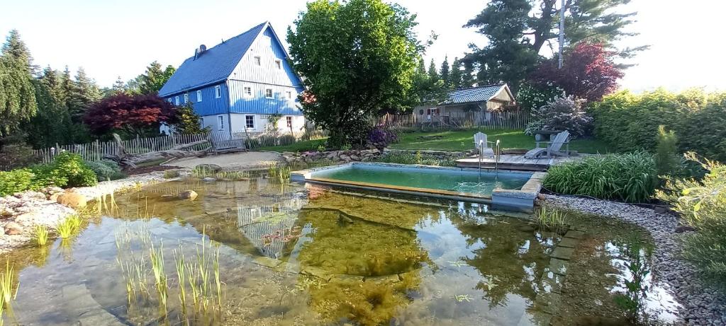 a house with a pond in front of a house at Blockstube in Rammenau