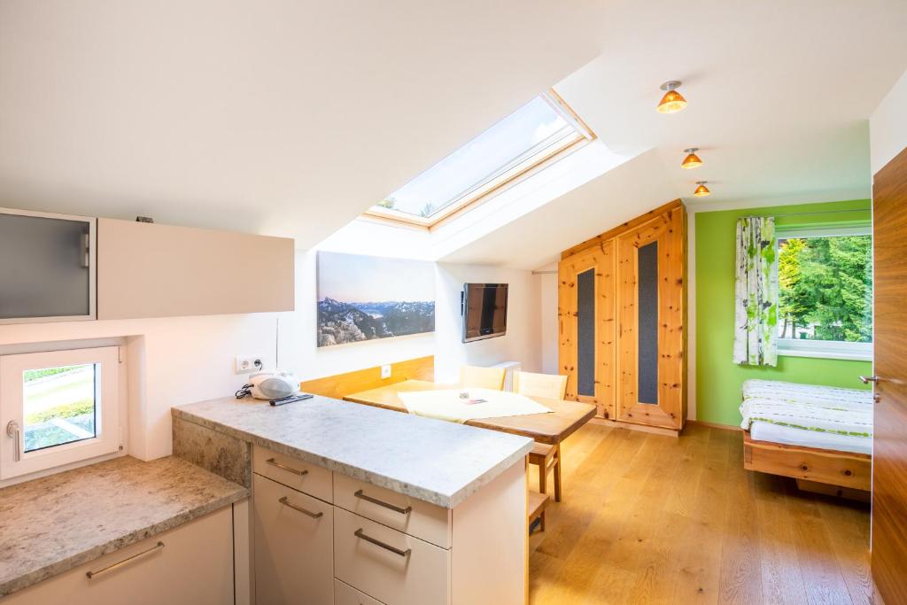 a kitchen with green walls and a skylight at Haus Bergblick in Fuschl am See