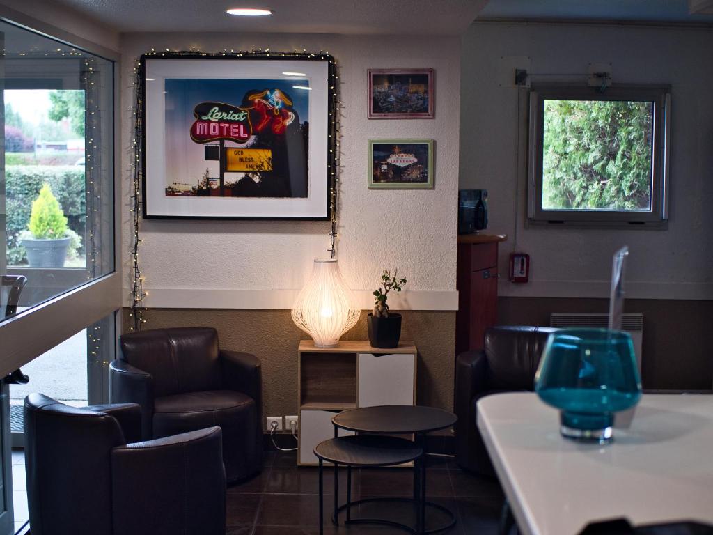 a restaurant with chairs and a table and a lamp at ibis budget Chartres in Chartres