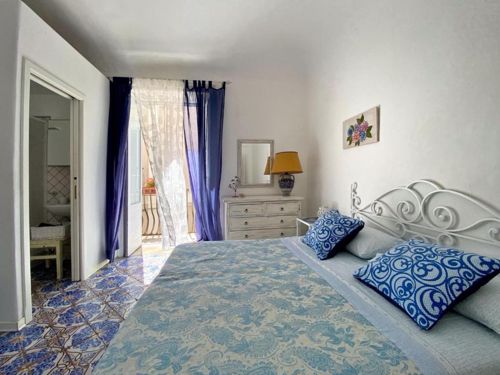 a bedroom with a large bed with blue pillows at Casa Chiara in Lipari