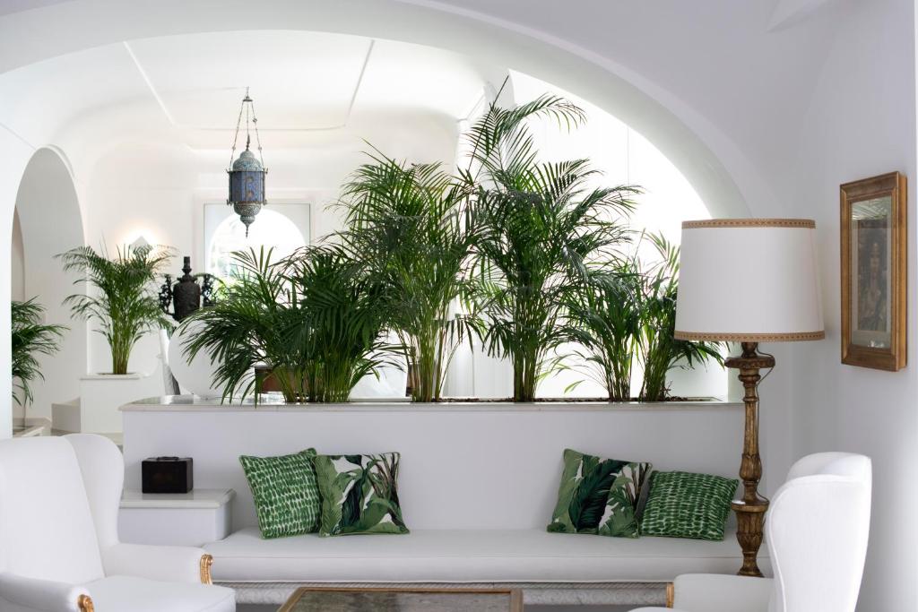 uma sala de estar com um sofá branco e plantas em Palazzo Don Salvatore em Amalfi