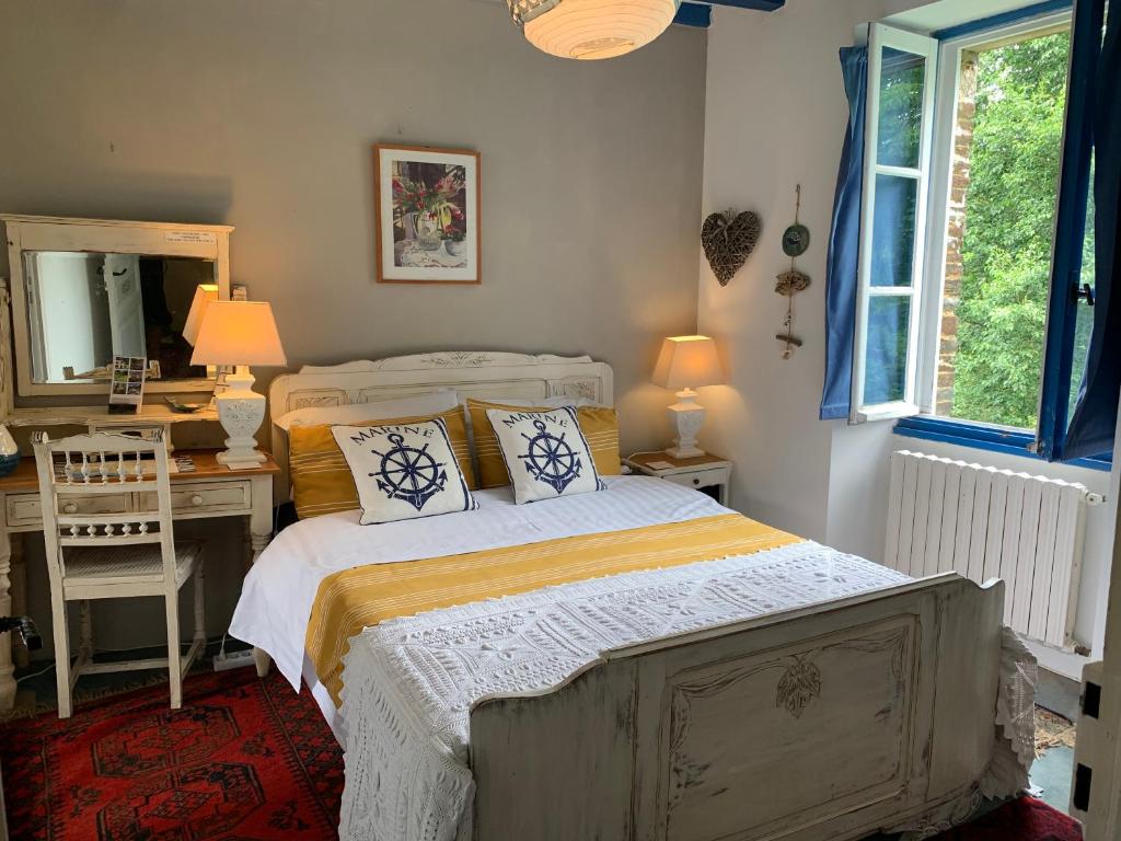 a bedroom with a bed and a desk and a mirror at Vingt Vieux Bourg in Rochefort-en-Terre