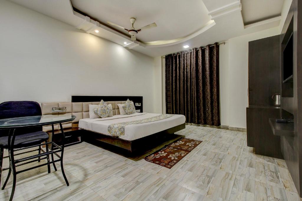 a hotel room with a bed and a table and a tableablish at FabHotel CSFC Near Bhopal Railway Station in Bhopal