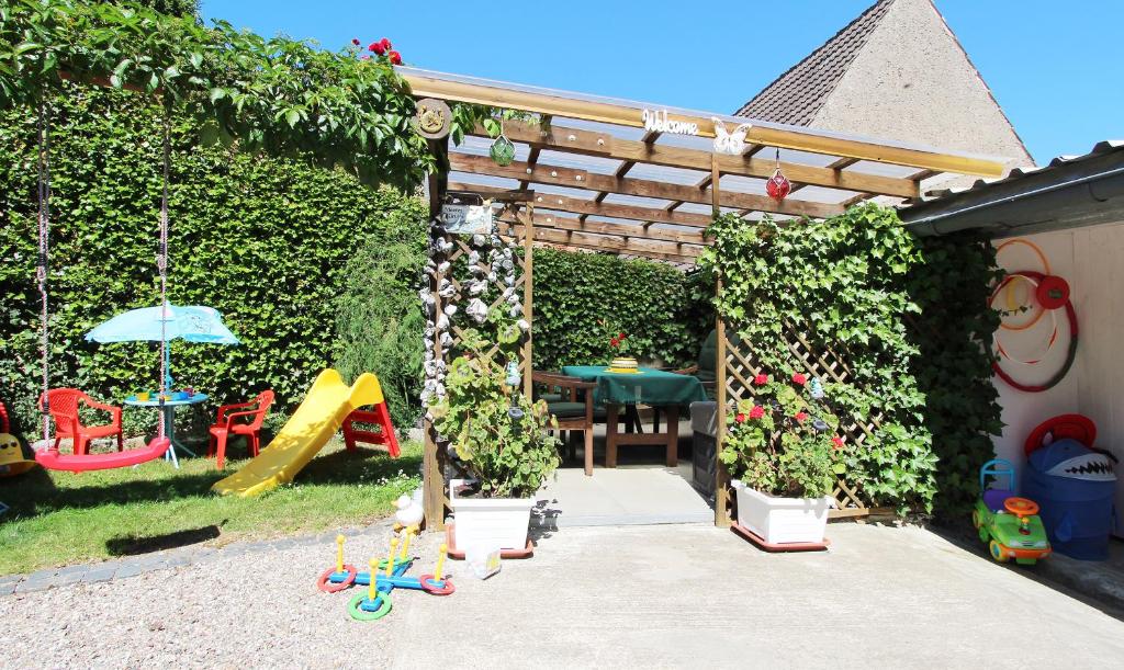 un giardino con tavolo, sedie e recinzione di Ferienwohnung Familienwohnung a Kröpelin