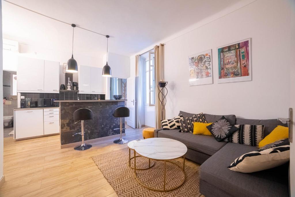 sala de estar con sofá, mesa y cocina en Smile Apartment en Cannes