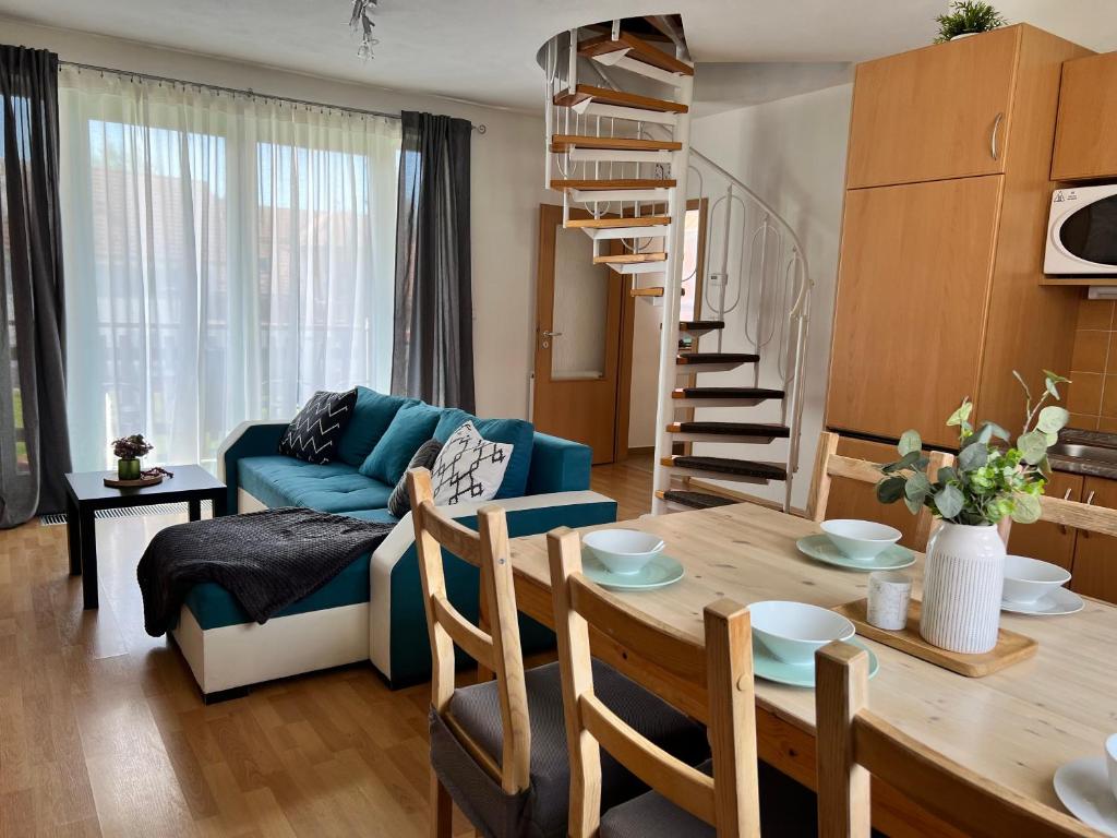 ein Wohnzimmer mit einem Tisch und einer Wendeltreppe in der Unterkunft Riviera Lipno 502-12 in Lipno nad Vltavou