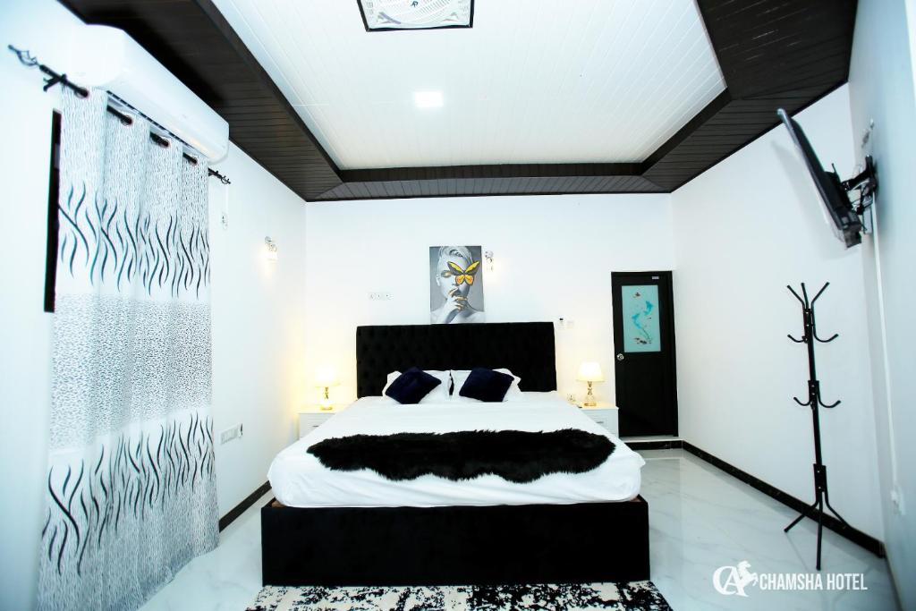 a bedroom with a bed with a black headboard at Chamsha Hotel in Anuradhapura