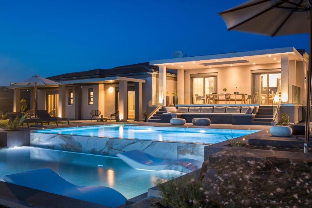 una piscina frente a una casa por la noche en Villa Royal, en Kaligata