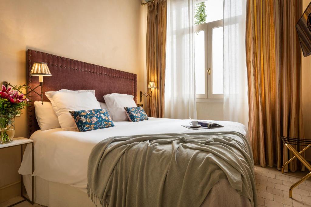 a bedroom with a large white bed with a window at CH Apartments Boutique in Seville