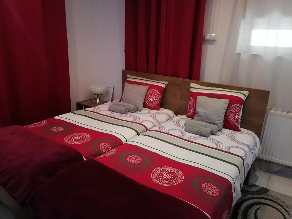a large bed with red and white sheets and pillows at Studio 6 in Târgu-Mureş