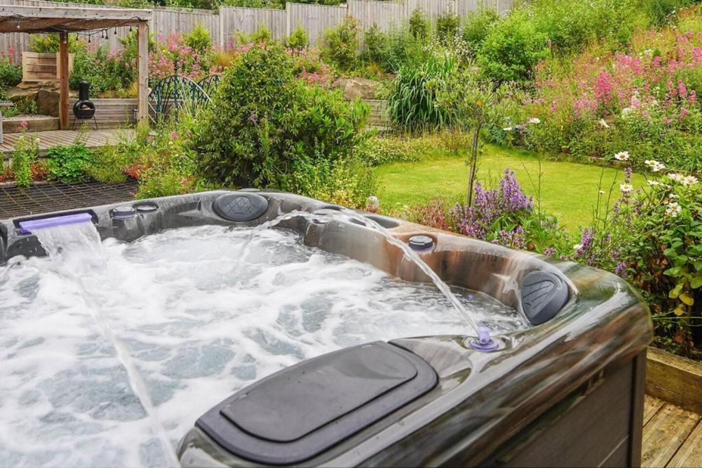 a hot tub with water in a garden at Luxury Spa Home With Hot Tub Sauna And Pool Table in Chesterfield