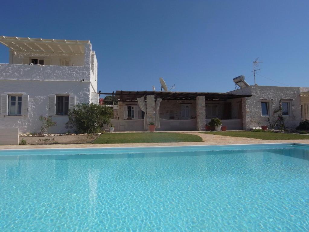 una piscina azul frente a una casa en Villa Naousa, en Naousa
