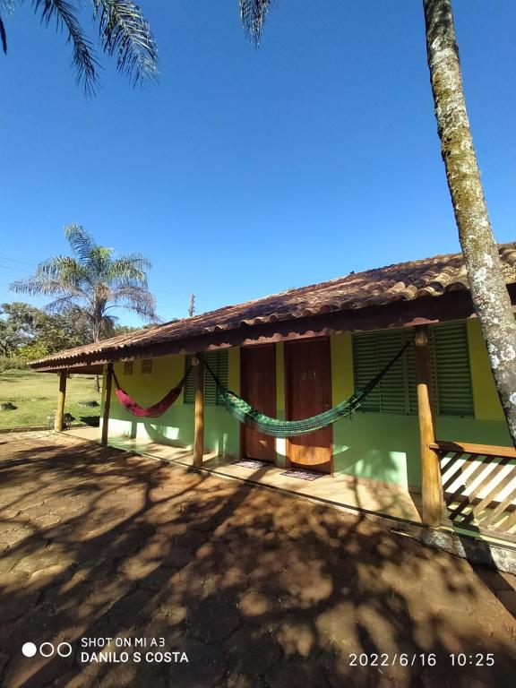 uma casa com uma rede em frente em Pousada, Camping e Restaurante Recanto do Surubim em São Roque de Minas