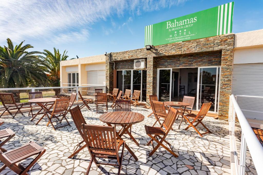 un patio avec des tables et des chaises en face d'un bâtiment dans l'établissement Hotel Bahamas, à Montevideo