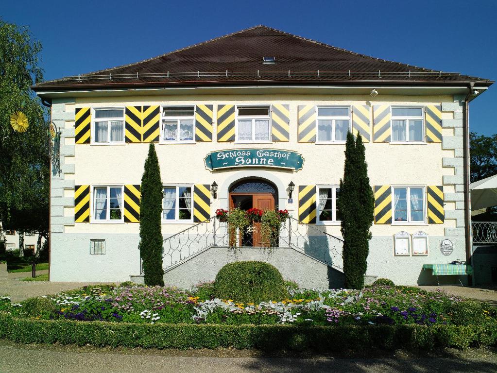 イスニー・イム・アルゴイにあるSchloss-Gasthof Sonneの黄白縞白白の建物