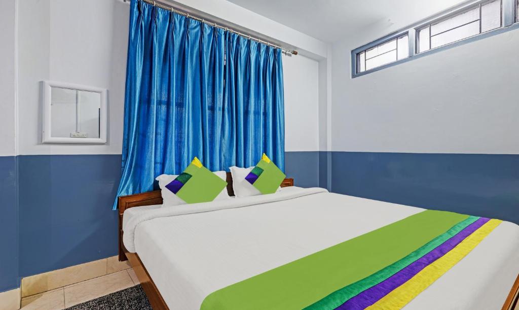 um quarto com uma cama grande e uma cortina azul em Itsy By Treebo - Shillong Tower Guesthouse em Shillong