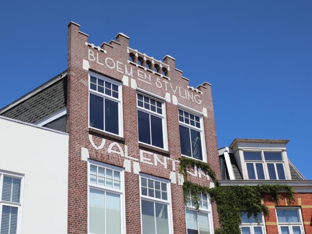 a brick building with a sign on the side of it at Stadslogement Valentijn in Sneek