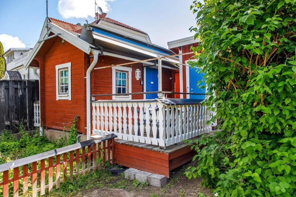una casa roja y azul con una valla blanca en Simple little cottage in a cozy courtyard in Vimmerby, en Vimmerby