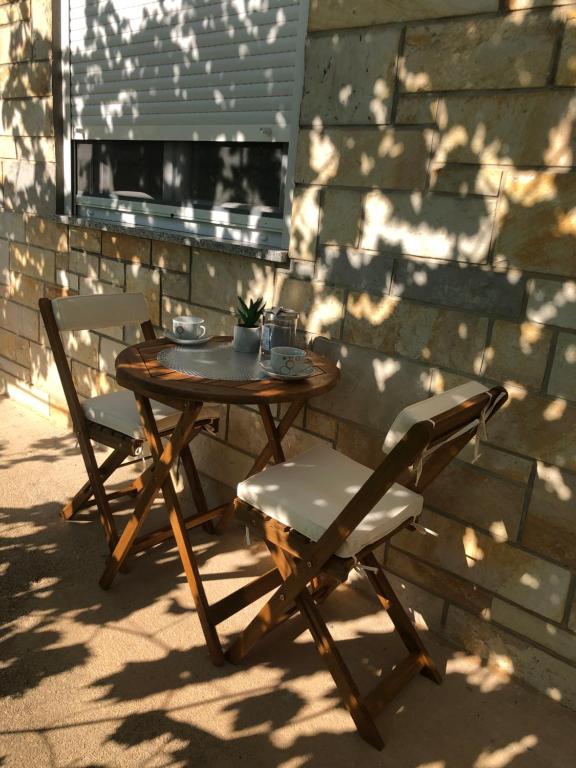una mesa de madera y 2 sillas en el patio en Apartman Ana Zadar en Zadar
