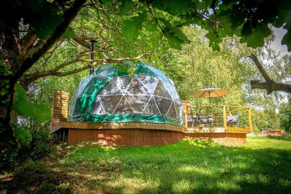 ein Glashaus mit einem Tisch und einem Sonnenschirm in der Unterkunft Finest Retreats - Chartwell Luxury Dome 