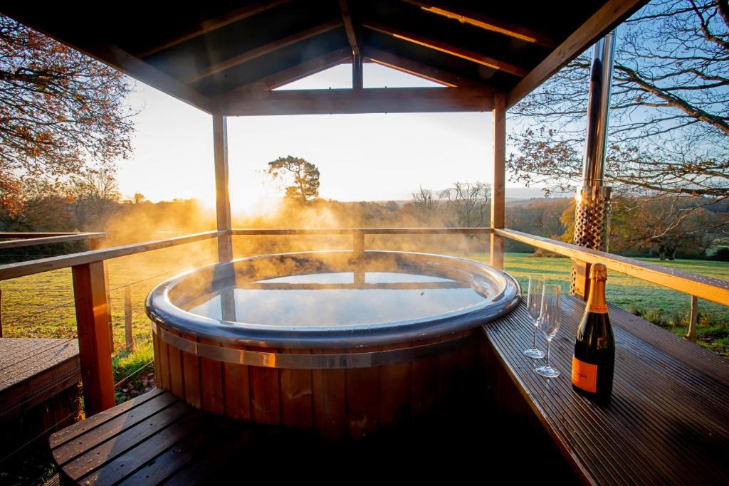 a hot tub on a deck with a bottle of wine at Finest Retreats - Knole Luxury Dome 