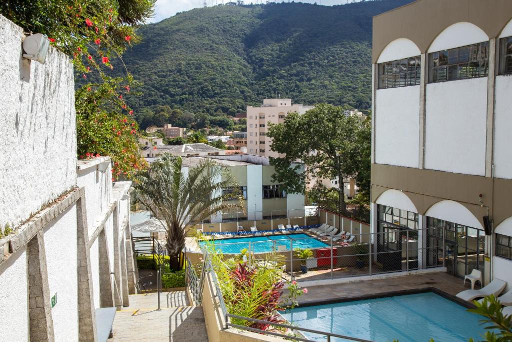 a view of a hotel with a swimming pool and mountains at SESC POÇOS DE CALDAS in Poços de Caldas