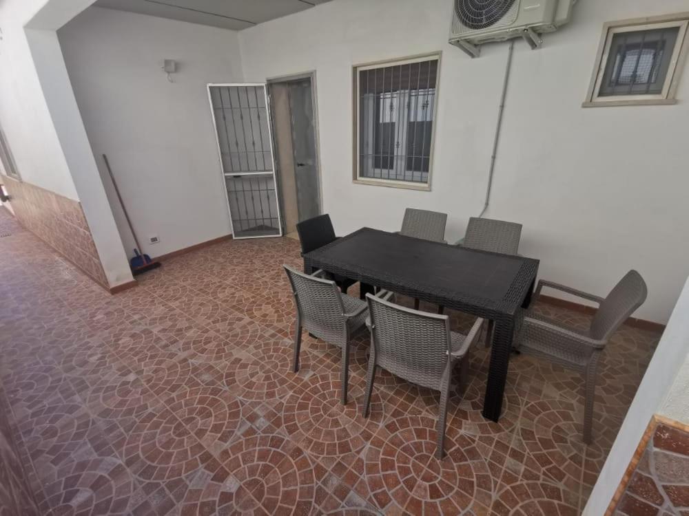 ein Esszimmer mit einem schwarzen Tisch und Stühlen in der Unterkunft Villa Luna - Villa Vacanze Indipendente & Climatizzata - Salento - Puglia - ITALY in San Pietro in Bevagna