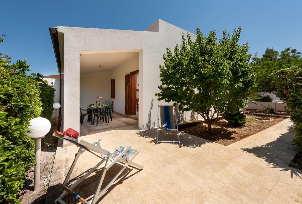 a house with a patio with a table and chairs at Casa Vacanza Azzurra 2 in San Vito lo Capo