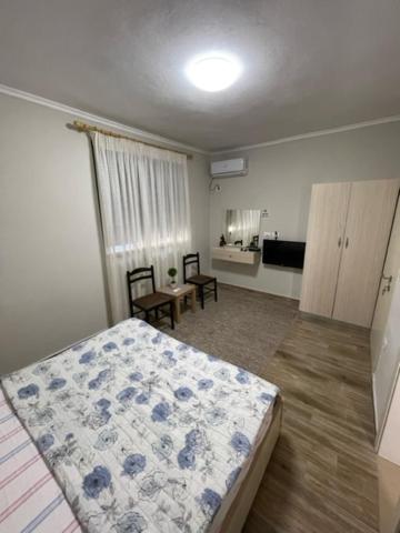 a bedroom with a bed and a room with a kitchen at New Bazaar Rooms in Tirana