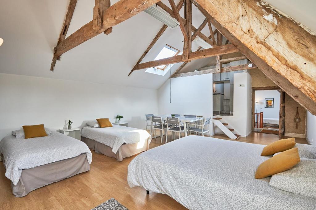a bedroom with two beds and a dining room at Le Manoir des Doyens Loft - Sleeps 8 - Breakfast Included! in Bayeux