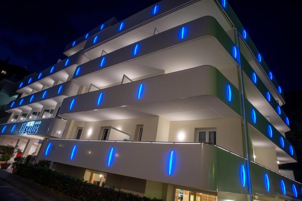 ein Gebäude mit blauen Lichtern an der Seite in der Unterkunft Hotel Salus in Lignano Sabbiadoro