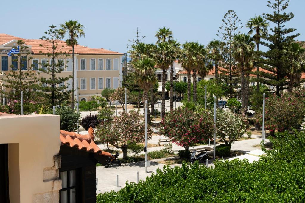 Blick auf einen Park mit Palmen und Gebäuden in der Unterkunft Fonte d'Oro Luxury Rooms in Rethymno
