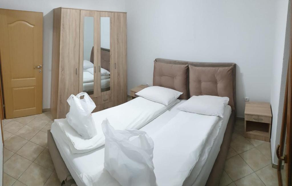 a bedroom with two beds with white sheets and a mirror at Apartmani Kuprešak 