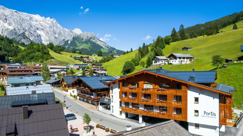 a town in the mountains with a green hill at Portis Appartements in Dienten am Hochkönig
