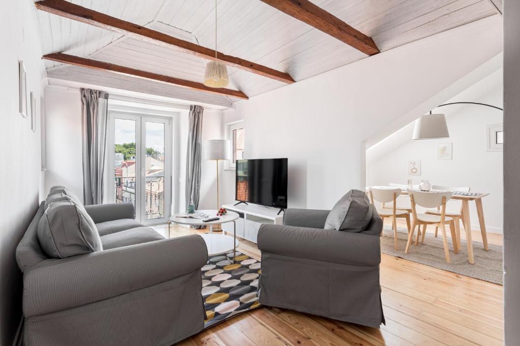 a living room with two chairs and a table at ALTIDO Stylish 2-bed Apt with balcony in Lapa, 5mins to National Museum of Ancient Art in Lisbon