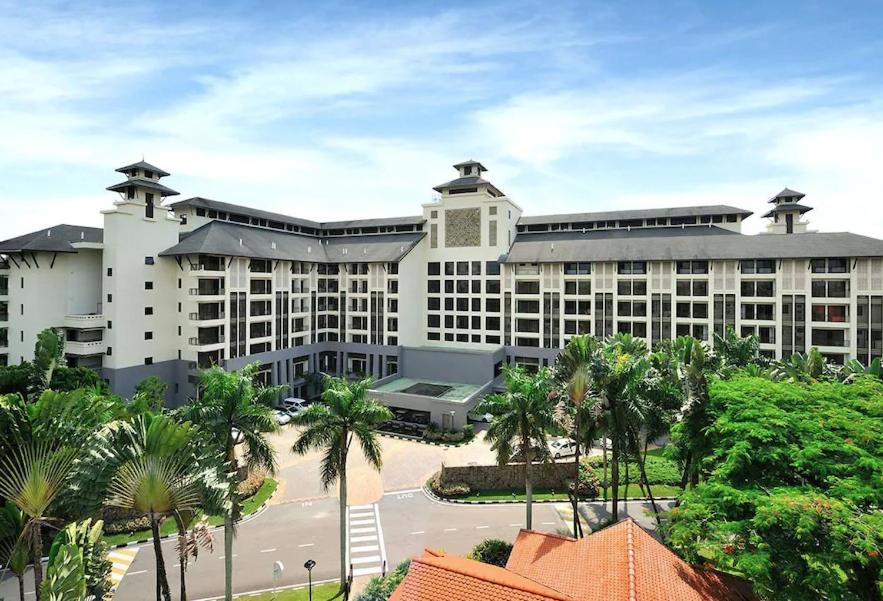 士古來的住宿－Garden View Pulai Springs Resort，一座白色的大建筑,前面有棕榈树