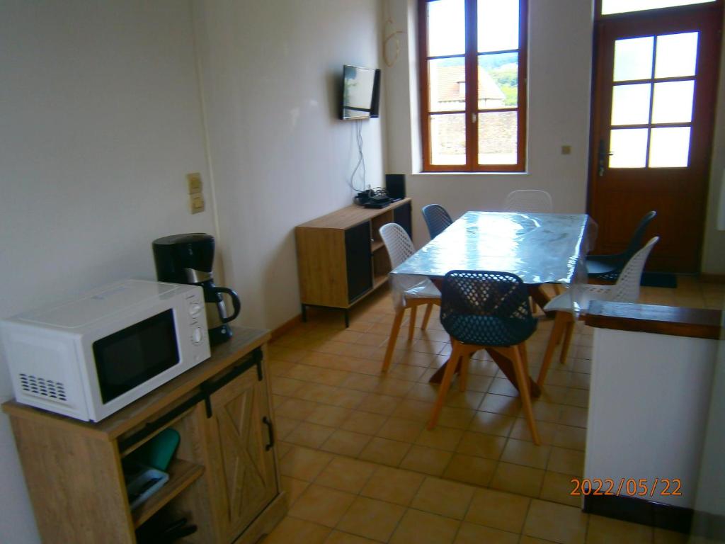 ein Wohnzimmer mit einem Tisch und einer Mikrowelle in der Unterkunft Agréable petite maison in Fécamp