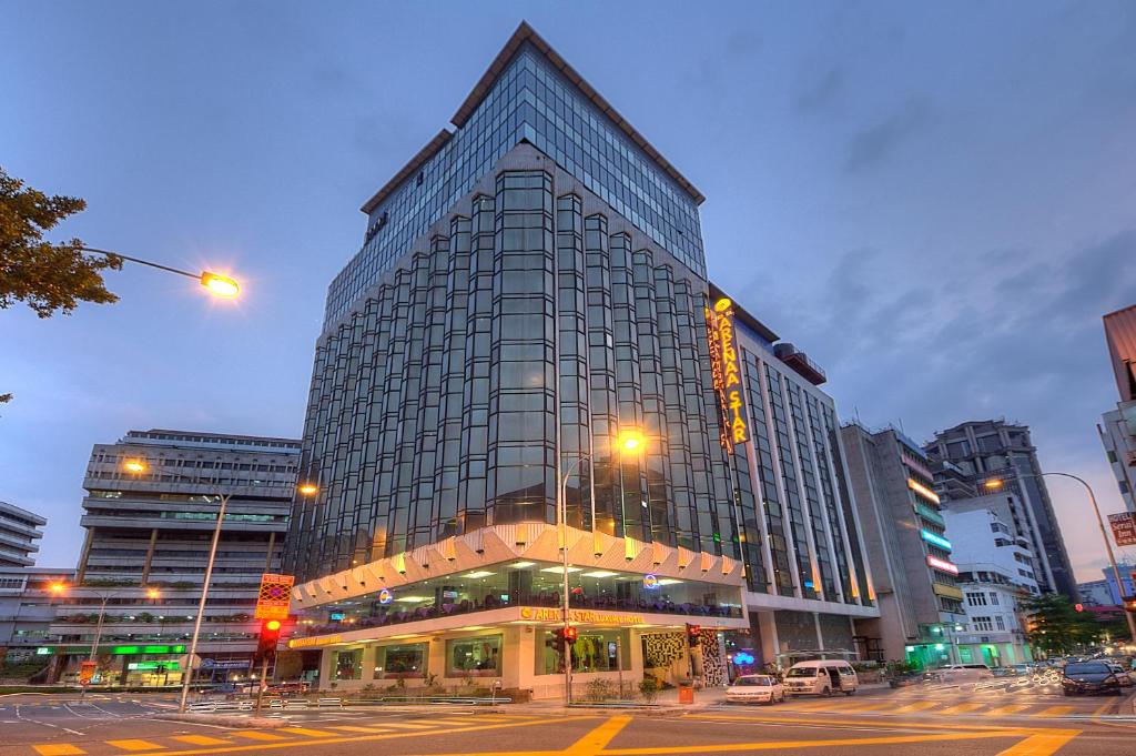 a large glass building in a city with a street at Arenaa Star Hotel in Kuala Lumpur