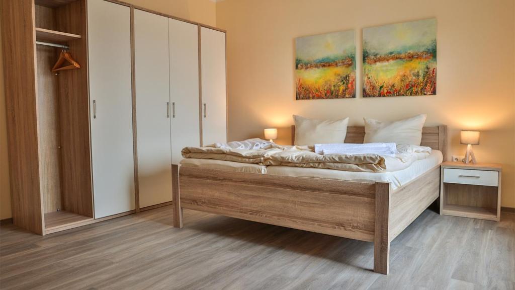 a bedroom with a bed and a painting on the wall at Wohnung "Stralsund" in Gützkow