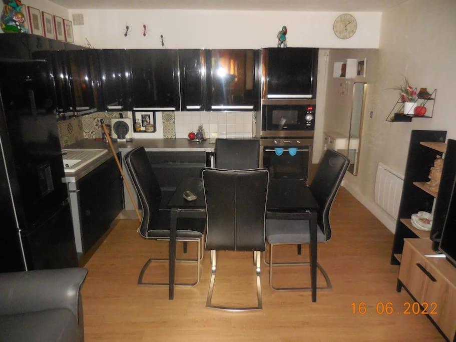 une cuisine avec des chaises noires et une table. dans l'établissement Grand studio à 2 pas de la mer, à Saint-Cyr-sur-Mer