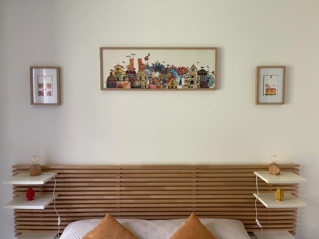ein Schlafzimmer mit einem Kopfteil aus Holz und einem Bild an der Wand in der Unterkunft Zanclea in Palermo