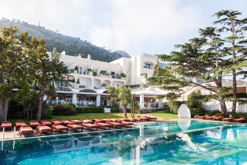 un hotel con piscina y sillas y un edificio en Jumeirah Capri Palace en Anacapri