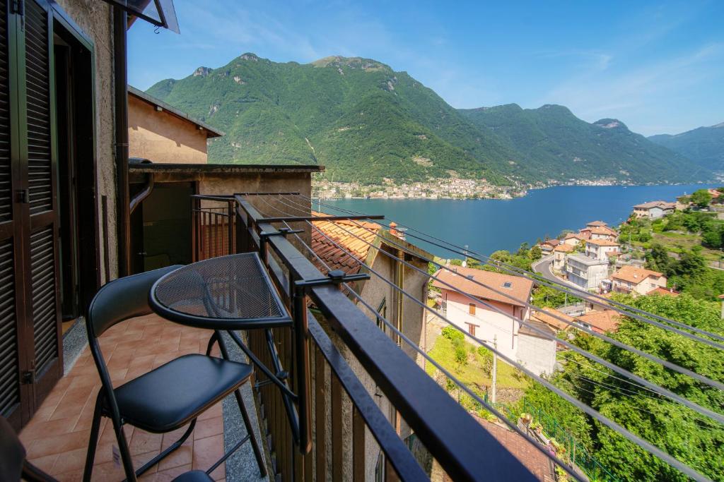 balcón con mesa y vistas al agua en The sound of silence en Pognana Lario