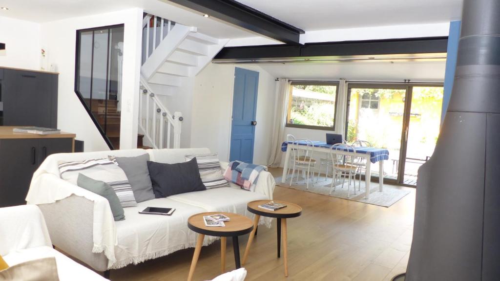 salon z białą kanapą i stołami w obiekcie Confortable maison de vacances 3 étoiles, 6p w mieście Ploeren