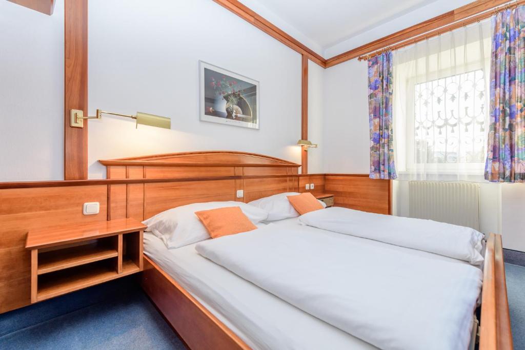 1 dormitorio con 2 camas y ventana en Gasthof Stöckler, en Enns