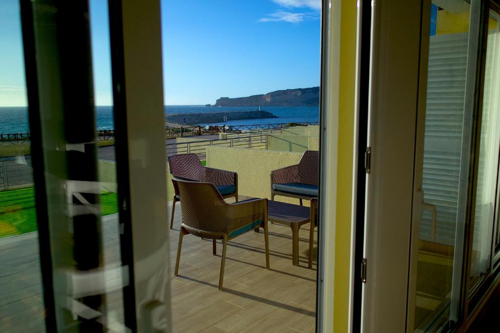 uma varanda com cadeiras e vista para o oceano em Resort Holidays Nazaré em Nazaré