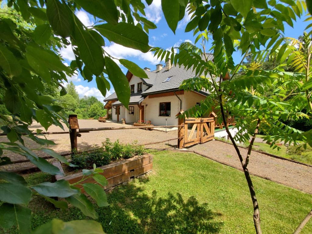 a house with a fence in front of a yard at Zagroda Berezanka 600-739-125 in Polańczyk